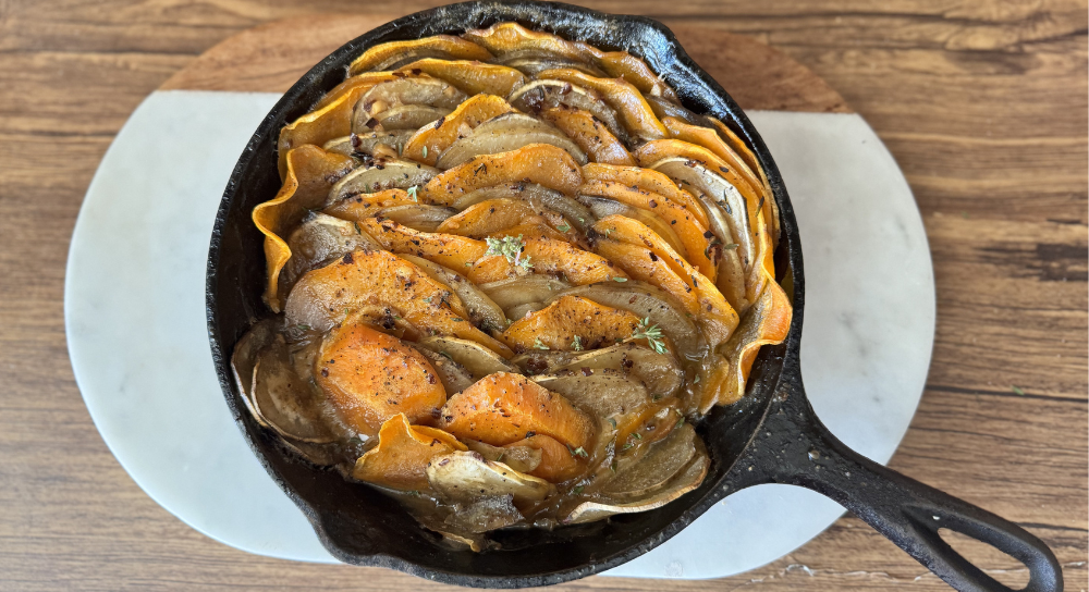 Image of baked sweet potato casserole layered with vegetables, a vegan, gluten-free and dairy-free dish cooked in a cast iron skillet.